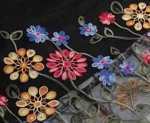 Detail of colorful floral embroidery and black mesh fabric on a 50s vintage dress