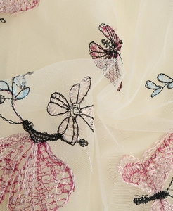 Gros plan sur la broderie papillon complexe sur un tissu en maille fine de haute qualité