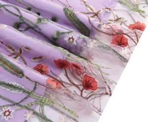 Detailed view of floral embroidery on purple mesh fabric for high-quality dresses
