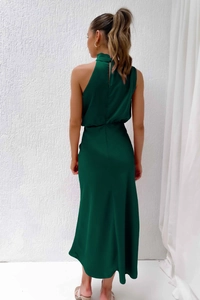 Detail of elegant satin backless halter dress featuring a sleek dark green silk texture