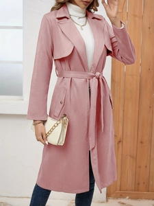 Detail of pink faux suede trench coat featuring a wide lapel and matching waist belt