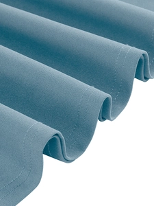 Détail de l'ourlet de robe en mousseline gris-bleu avec double couture précise et texture