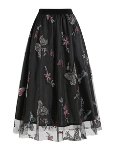 Gros plan sur la broderie de papillons colorés sur jupe midi en tulle noir multicouche