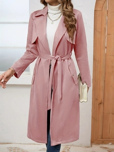 Detail of pink faux suede trench coat featuring waist belt and metallic pocket buttons