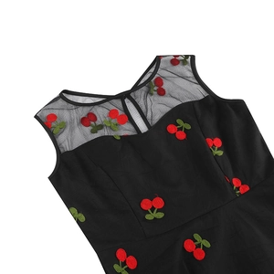 Détail de l'encolure en résille noire et broderie cerise rouge sur une robe sans manches