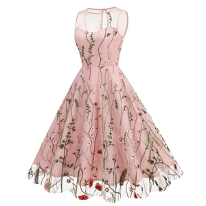 Detail of pink mesh dress featuring intricate green leaf and red floral embroidery accents