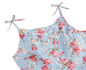 Detail of light blue floral dress with white buttons and adjustable tie-up shoulder straps