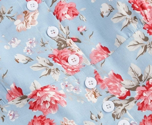 Close-up of white buttons and floral print texture on a vintage Audrey Hepburn dress