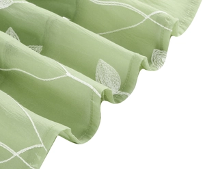 Detaillierte Nahaufnahme von hellgrünem Chiffon mit weißer Blattstickerei und Wellenlinien