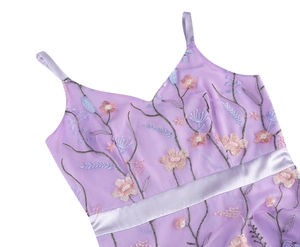 Close-up of floral embroidery on purple tulle dress with a lavender satin ribbon belt