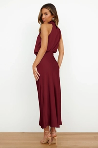 Detail of elegant dark red satin maxi dress featuring a halter neck and silky texture