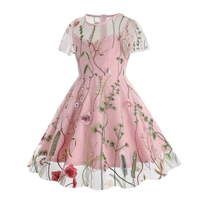 Detail of pink girls' dress featuring delicate floral embroidery on sheer mesh fabric