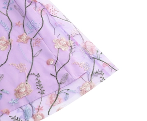 Detailed close-up of pink floral embroidery on light purple mesh lace evening dress