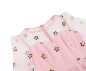 Detailed view of pink mesh neckline and sparkling gold star sequins on the dress