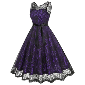 Détail de la superposition de dentelle florale et du large nœud en satin noir sur la robe