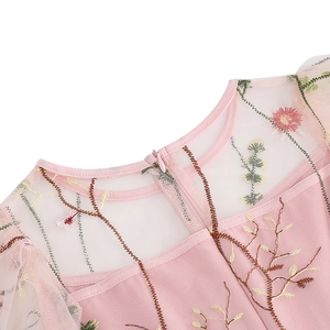 Close-up of pink girl's dress neckline with floral embroidery and invisible zipper detail