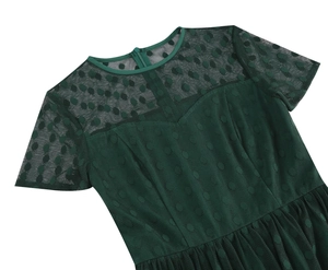 Close-up of green cocktail dress showing polka dot mesh stitching and invisible zipper detail