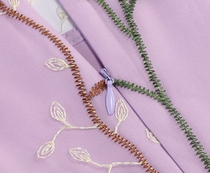 Close-up of violet mesh dress featuring intricate leaf embroidery and a smooth hidden zipper