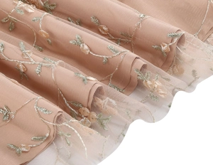 Detail of floral vine embroidery on multi-layered pink mesh fabric for elegant evening dress