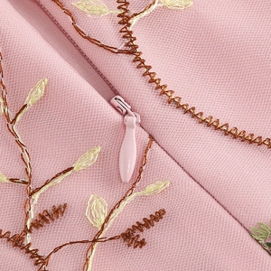 Detail of pink embroidered girls dress with invisible zipper and floral embroidery pattern