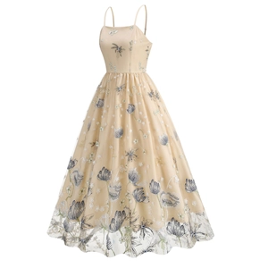 Close-up of elegant champagne mesh dress featuring blue floral embroidery and strap details
