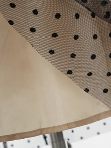Detail der Netzschicht mit beflockten Punkten über kaffeebraunem Innenfutterstoff