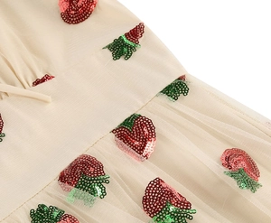 Close-up of strawberry sequin embroidery on beige mesh fabric for vintage dress