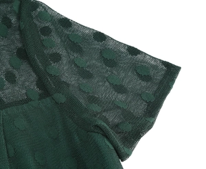Detail of dark green 1950s dress featuring polka dot mesh sleeves and fabric texture