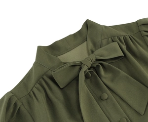 Détail de la robe vert olive avec col lavallière, épaules plissées et boutons recouverts