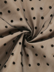 Detailaufnahme von schwarzem Mesh-Stoff mit Polka Dots und eleganter Faltenstruktur