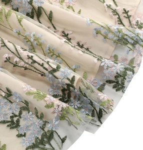 Detailed close-up of floral embroidery on vintage mesh tulle evening dress fabric