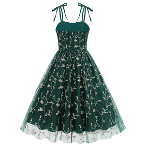 Detail of dark green mesh dress featuring white floral embroidery and bow shoulder straps
