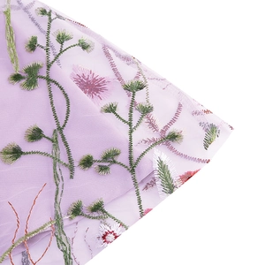 Close-up of intricate floral embroidery on purple mesh fabric for girl's dress