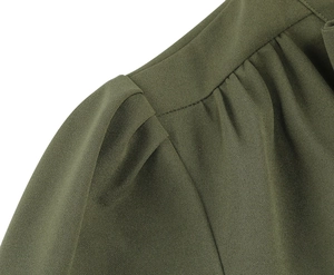 Détail de l'épaule d'une robe vert olive avec coutures plissées et tissu tissé texturé