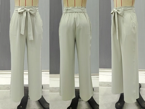 Detailed view of high waist wide leg pants with pleated paperbag waist and bow belt