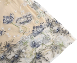 Close-up detail of sophisticated floral embroidery on champagne mesh cocktail dress skirt