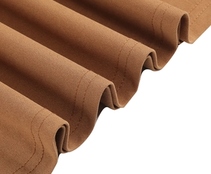 Détail macro du tissu plissé marron chameau avec ourlet propre à double aiguille