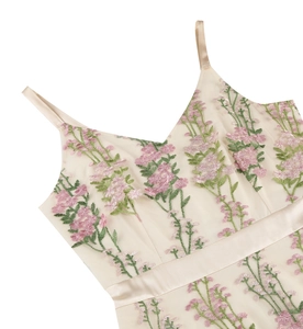 Detail of floral embroidery on cream V-neck dress with pink flowers and satin waistband
