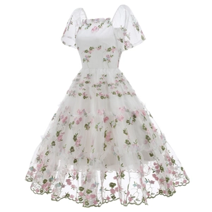 Detailed close-up of pink floral embroidery and mesh layers on a white 50s vintage dress