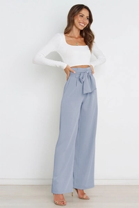 Detail of high waisted wide leg pants with elegant bow-knot waist tie and draped fabric