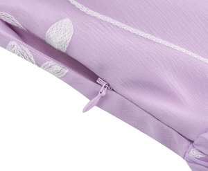 Detaillierte Makroansicht des hellvioletten Stoffes mit weißer Stickerei und Reißverschluss