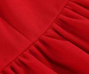 Macro shot of red vintage dress fabric detailing pleats and fine woven texture