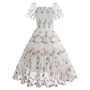 Close-up of floral embroidery on white mesh tiered cake dress with puff sleeves