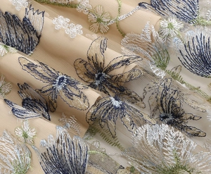 Macro shot of intricate blue floral embroidery on beige sheer mesh fabric with fine stitching