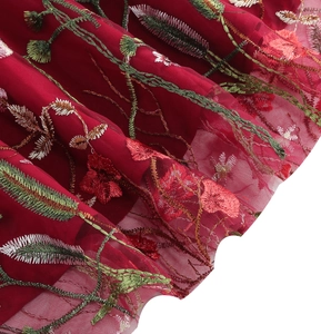 Close-up of wine red girl dress featuring delicate floral embroidery on fine mesh fabric