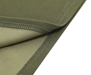 Détail de l'ourlet de robe vert olive montrant des coutures de qualité et du tissu