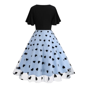 Detailed view of the vintage mesh embroidery layers with black heart patterns and blue fabric