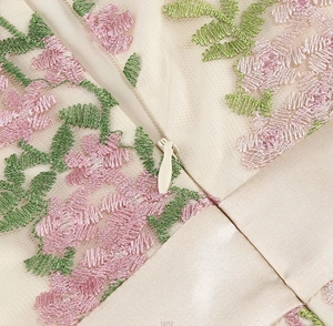 Macro shot of 3D floral embroidery and seamless invisible zipper on champagne dress