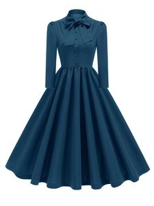 Détail de la robe vintage bleu canard avec encolure à nœud et boutons élégants