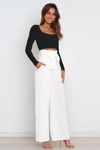 Detail of high waisted wide leg trousers with a stylish bow tie waist in white